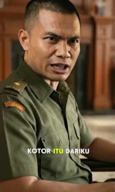 An army officer in uniform shouts across a desk.